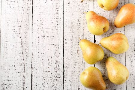 Ripe pears on white wooden tableの写真素材