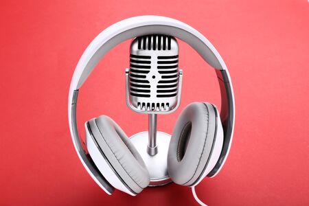 Vintage microphone with headphones on red backgroundの写真素材