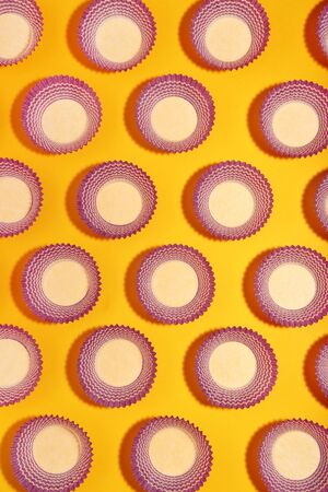 Cupcake cases on yellow background. Minimalism conceptの写真素材