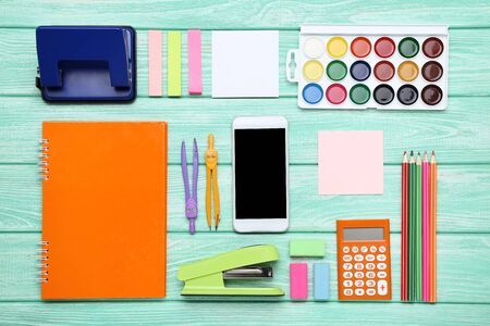 School supplies with smartphone on mint wooden tableの写真素材