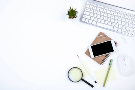 Smartphone, keyboard computer with mouse, notepad and green plant on white backgroundの写真素材