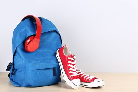 School backpack with headphones and sneakers on grey backgroundの写真素材