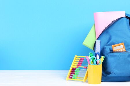 Backpack with school supplies on blue backgroundの写真素材
