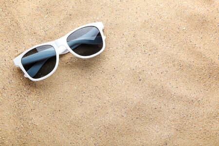 Modern sunglasses on the beach sandの写真素材
