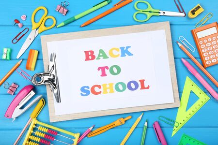 Text Back To School on clipboard with stationery on blue wooden tableの写真素材