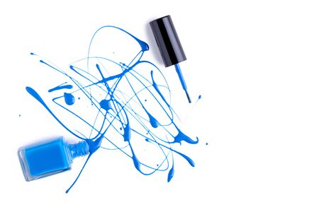 Blue nail polish splatters and bottle on white backgroundの写真素材