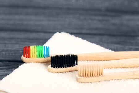 Bamboo toothbrushes with towel on black wooden table