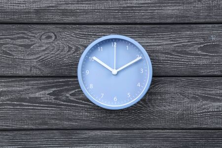Blue round clock on black wooden table