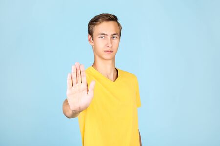 Portrait of young man in yellow t-shirt on blue background