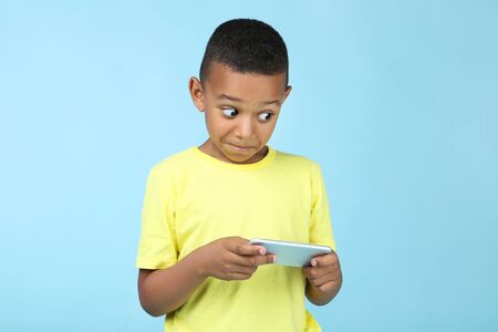 Cute american boy playing on mobile phoneの写真素材