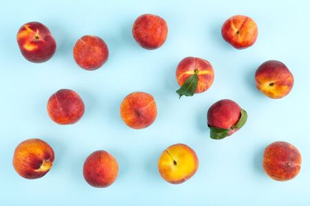 Fresh peaches with green leafs on blue background