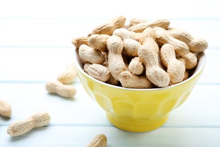 Peanuts in bowl on wooden table