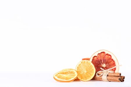 Dried citrus fruits with cinnamon on white background