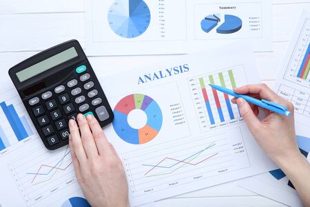 Woman working with financial papers, calculator and penの写真素材
