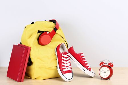 School backpack with headphones, sneakers and alarm clock on grey backgroundの写真素材