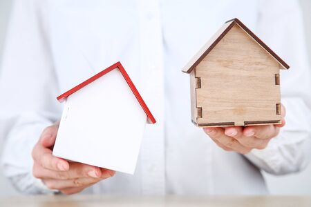 Female hands holding wooden house models