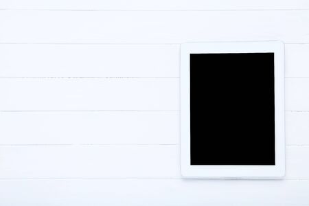 Tablet computer on white wooden table
