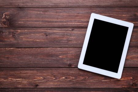 Tablet computer on brown wooden table