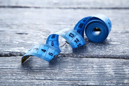 Blue measuring tape on grey wooden table