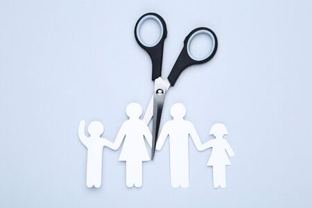 Family figures with scissors on grey backgroundの写真素材