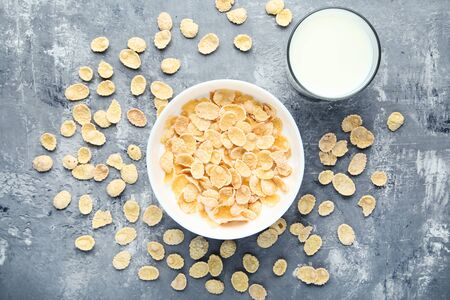Corn flakes with glass of milk on grey wooden tableの写真素材