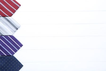 Colored neckties on white wooden tableの写真素材