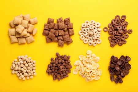 Various corn flakes on yellow