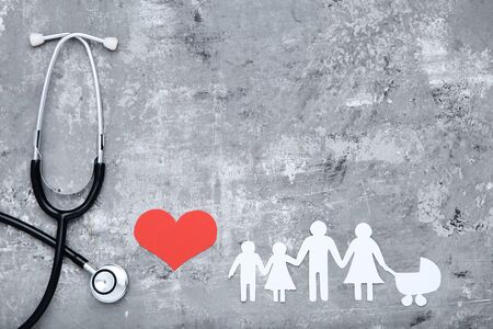 Family figures with red heart and stethoscope on grey backgroundの写真素材