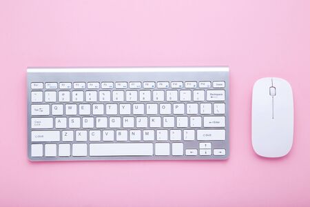 Computer keyboard and mouse on pink backgroundの写真素材