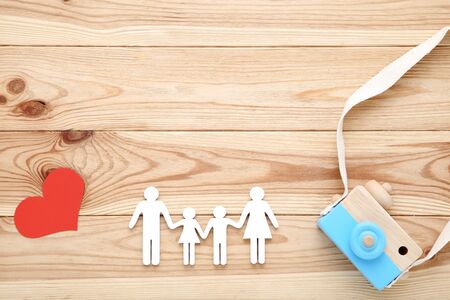Family figures with red heart and wooden camera on brown wooden backgroundの写真素材
