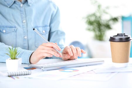 Female hands typing on computer keyboard and working with diagramsの写真素材