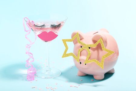 Piggybank with cocktail in glass on blue background. Minimalism conceptの写真素材
