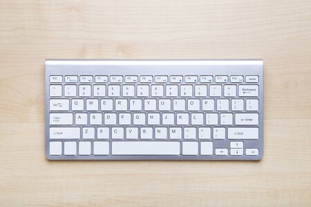 Computer keyboard on brown wooden table