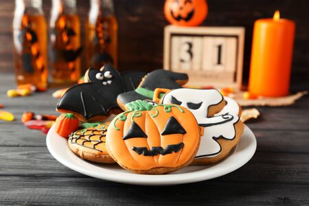 Halloween gingerbread cookies in plate on wooden tableの写真素材