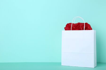 Paper shopping bag on mint background