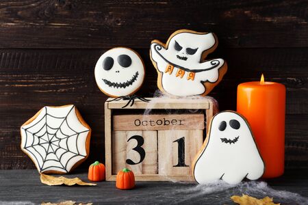 Halloween gingerbread cookies with wooden calendar and candleの写真素材
