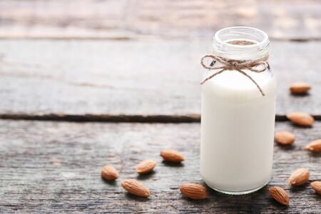 Almond milk in bottle on grey wooden tableの写真素材