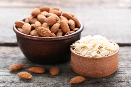 Almonds in bowls on grey wooden tableの写真素材
