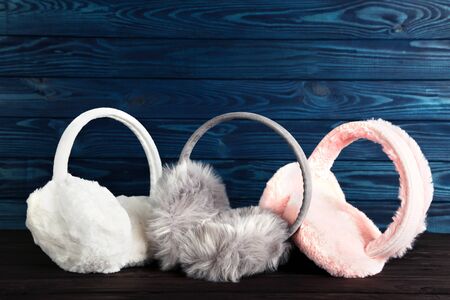 Colorful furry earmuffs on wooden table