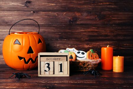 Halloween cookies with wooden calendar, candles and pumpkin bucketの写真素材