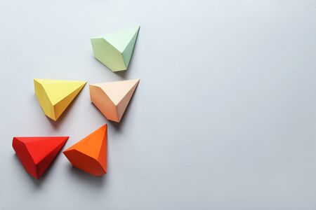 Colorful paper geometric figures on grey background