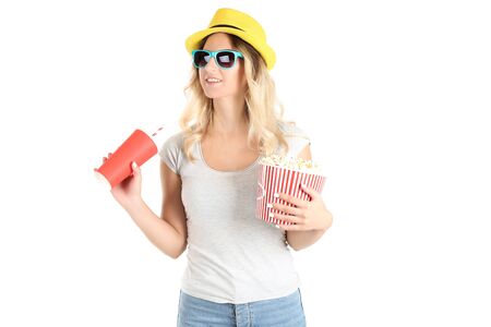 Young woman holding bucket with popcorn and paper cup on white backgroundの写真素材