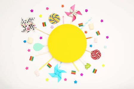 Colorful flat lay composition with various party items and candies on white backgroundの写真素材