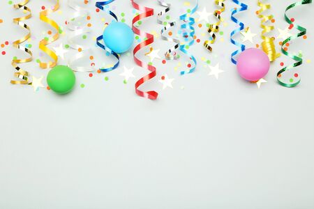 Colorful ribbons with rubber ballons and confetti on grey backgroundの写真素材