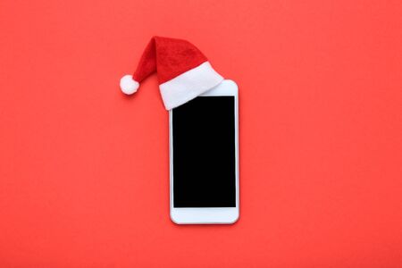 Santa hat with smartphone on red backgroundの写真素材