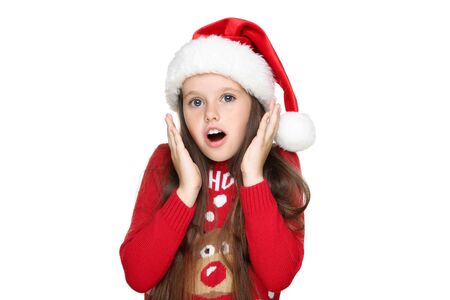 Little girl in christmas sweater and hat isolated on white backgroundの写真素材