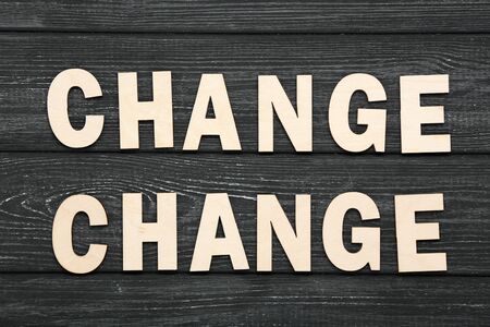 Word Change by wooden letters on black table