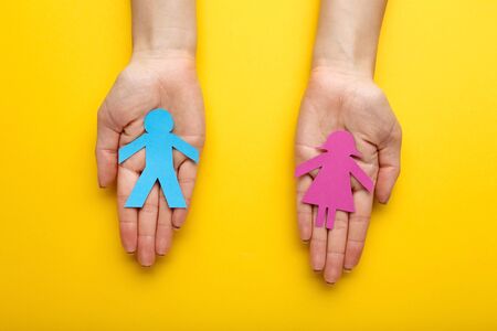 Paper chain people with female hands on yellow backgroundの写真素材