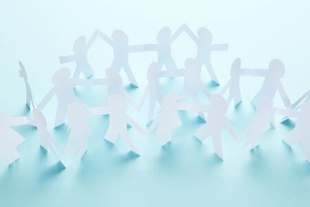 Paper chain people on yellow backgroundの写真素材