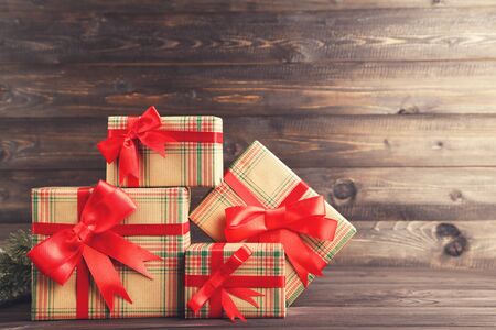 Gift boxes with ribbons on brown wooden table